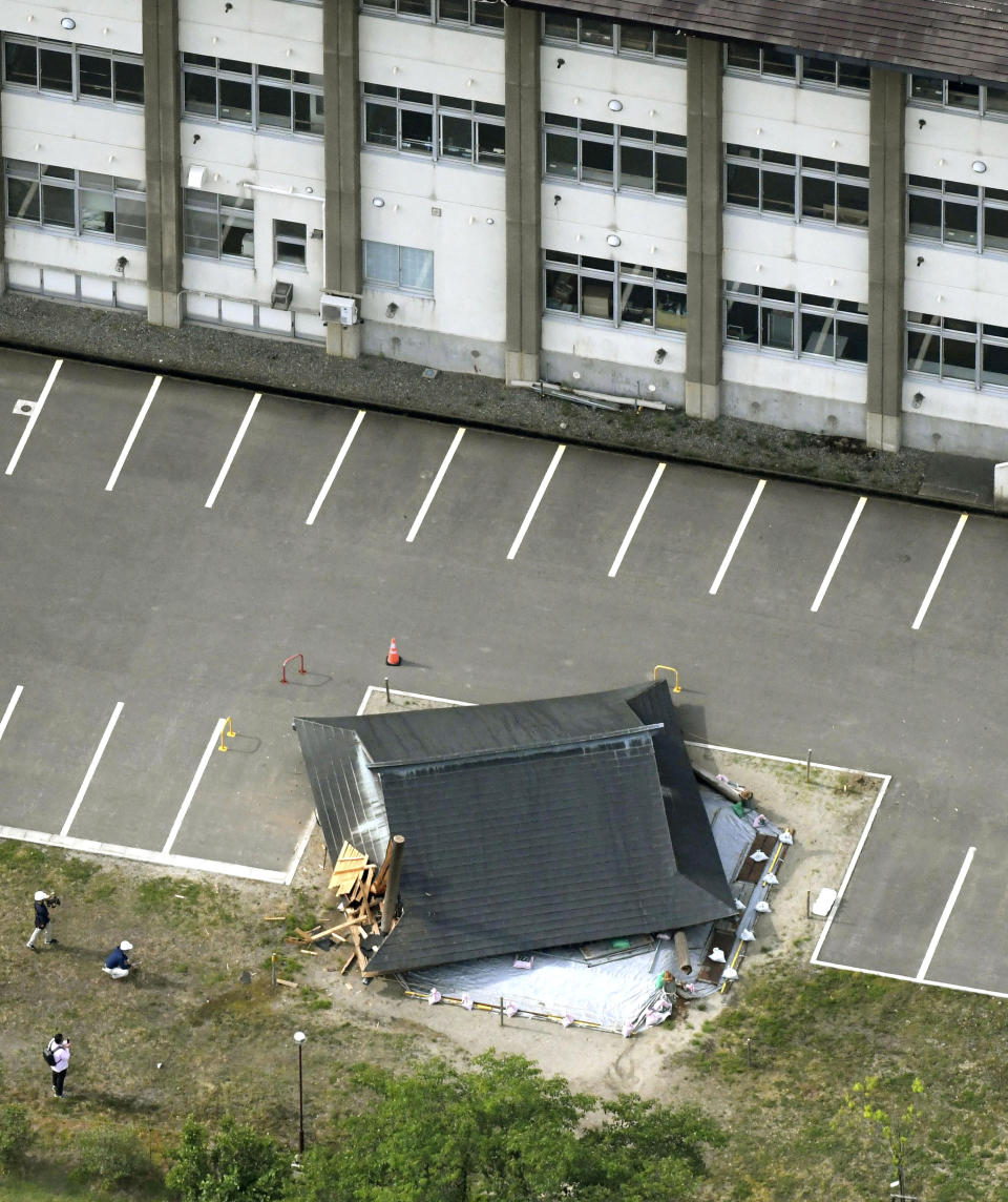 The roof of the wooden sumo building falls on the site of the Oizumi Elementary School in Tsuruoka, Yamagata prefecture, northwestern Japan, Wednesday, June 19, 2019, after an earthquake. The powerful earthquake jolted northwestern Japan late Tuesday, prompting officials to issue a tsunami warning along the coast which was lifted about 2 ½ hours later. Tsuruoka city officials were helping coastal residents evacuate to higher ground as a precaution. (Kyodo News via AP)