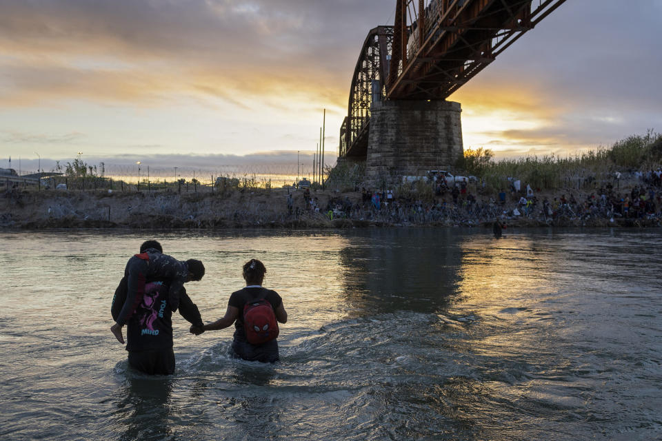 An immigrant family wades through the Rio Grande while crossing from Mexico into the United States on Sept. 30, 2023, in Eagle Pass, Texas.