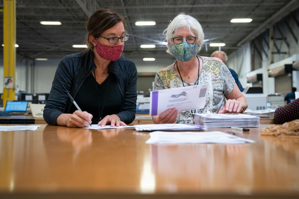 Working in bipartisan pairs, canvassers process mail-in ballots Oct. 7, 2020, in a warehouse at the Anne Arundel County Board of Elections headquarters in Glen Burnie, Md.