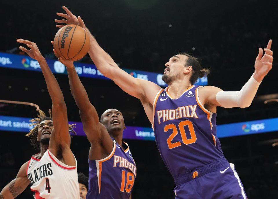 Nov 5, 2022; Phoenix, AZ, USA; Phoenix Suns center 	Dario Saric (20) grabs a defensive rebound over Portland Trail Blazers forward Greg Brown III (4) at Footprint Center.