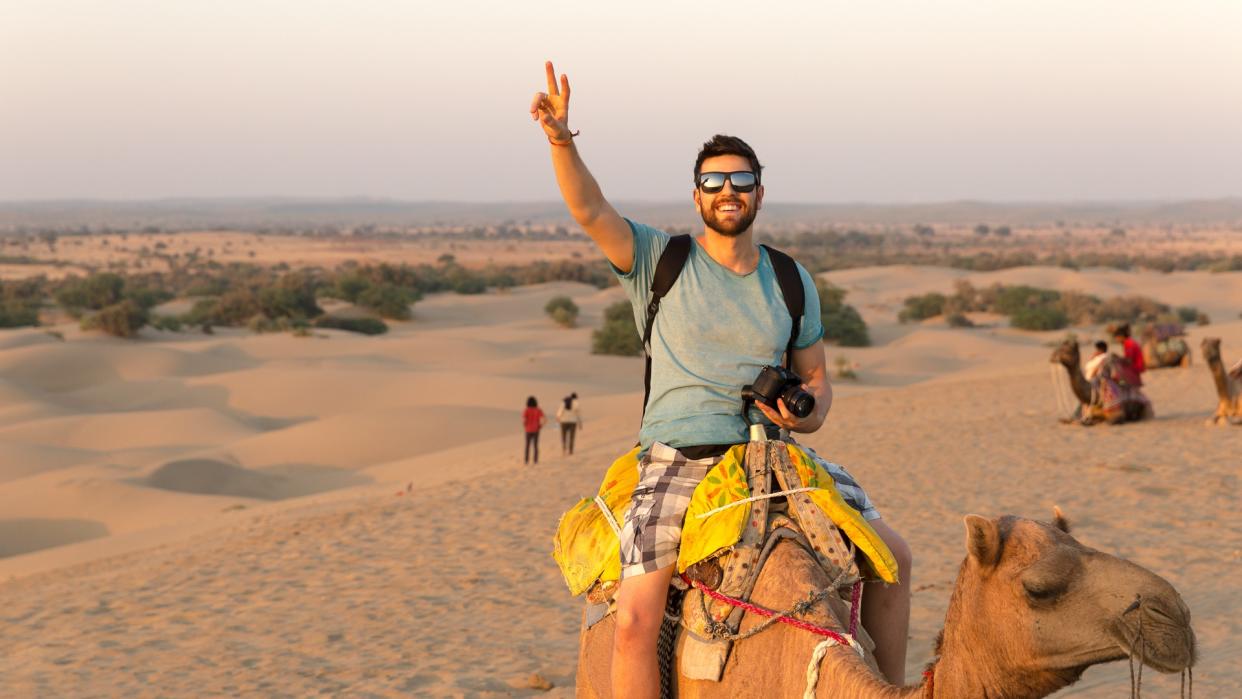 Tourist riding camel in Desert.