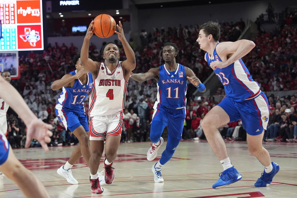 Houston's L.J. Cryer (4) drives toward the basket as Kansas's Parker Braun (23) and Jamari McDowell (11) defend during the second half of an NCAA college basketball game Saturday, March 9, 2024, in Houston. Houston won 76-46. (AP Photo/David J. Phillip)