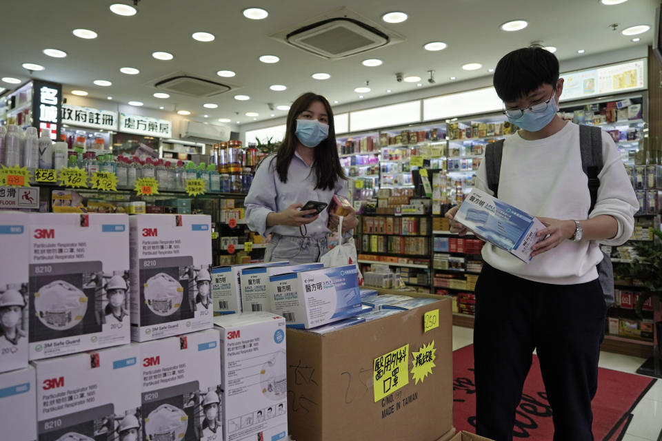 Customers purchase protective face masks at a pharmacy in Hong Kong, Thursday, Jan. 23, 2020. China closed off a city of more than 11 million people Thursday, halting transportation and warning against public gatherings, to try to stop the spread of a deadly new virus that has sickened hundreds and spread to other cities and countries in the Lunar New Year travel rush. (AP Photo/Kin Cheung)