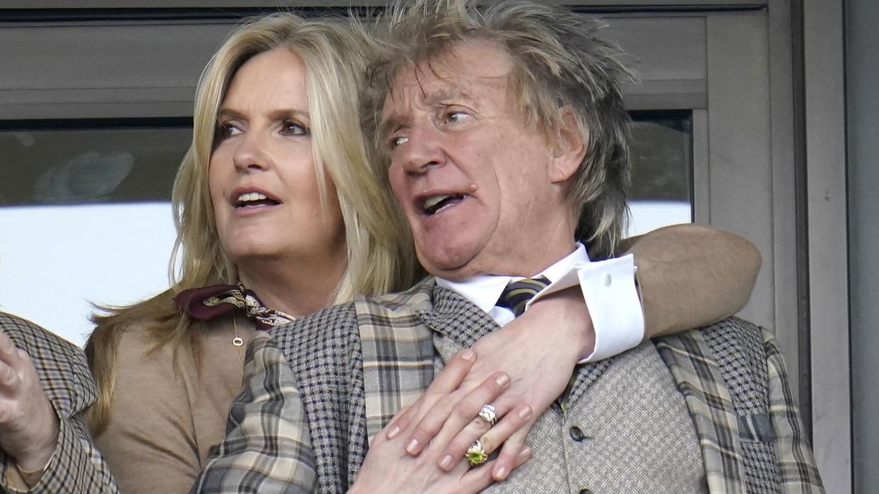 Penny Lancaster hugging Rod Stewart from behind