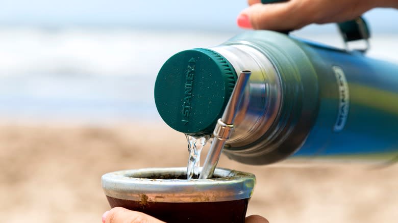 Person pouring liquid into cup