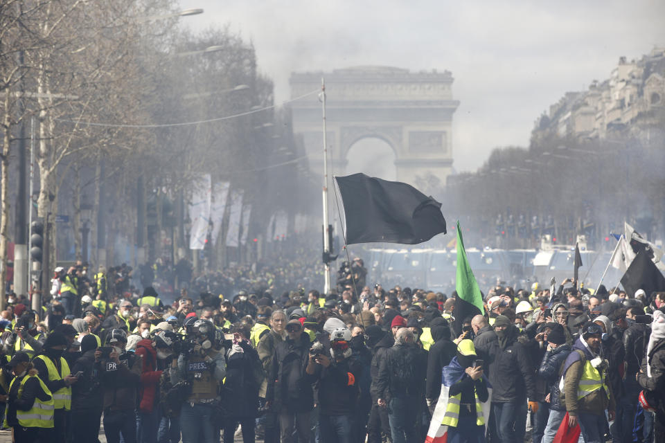 A black flag flies during a yellow vests demonstration on the Champs Elysees avenue Saturday, March 16, 2019 in Paris. French yellow vest protesters clashed Saturday with riot police near the Arc de Triomphe as they kicked off their 18th straight weekend of demonstrations against President Emmanuel Macron. (AP Photo/Christophe Ena)