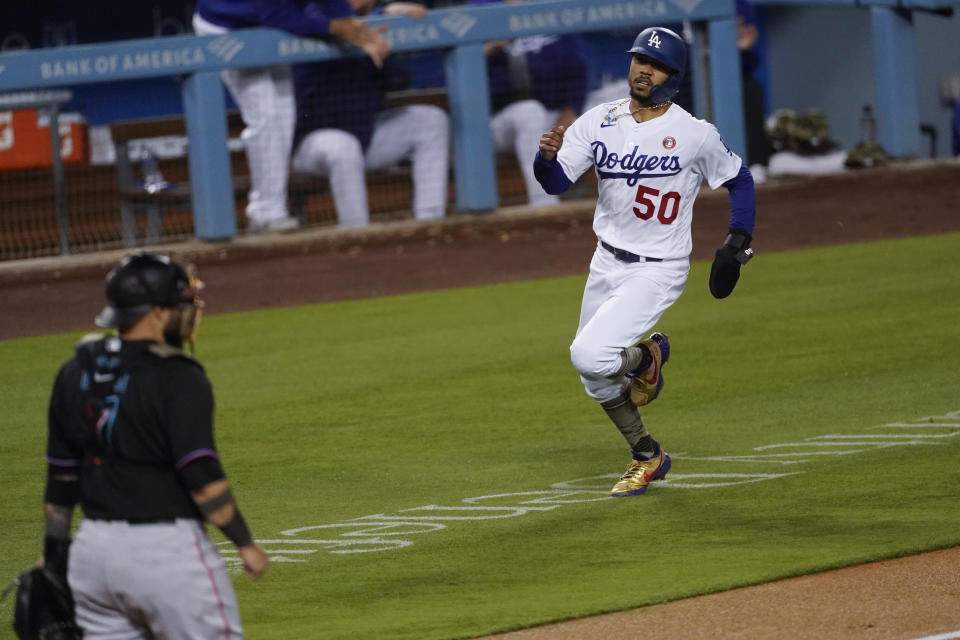 Los Angeles Dodgers' Mookie Betts (50) runs home to score off of a single hit by Max Muncy during the fifth inning of a baseball game against the Miami Marlins Saturday, May 15, 2021, in Los Angeles. (AP Photo/Ashley Landis)