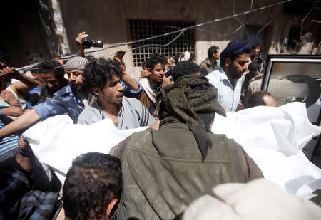 Yemeni men carry a body of a dead woman, who was killed by Saudi-led air strike in Sanaa, Yemen May 16, 2019. REUTERS/Mohamed al-Sayaghi