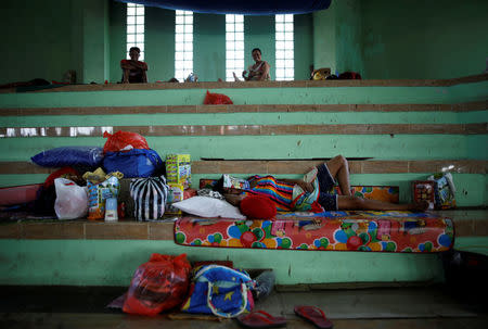 A woman sleeps inside a temporary evacuation center for people living near Mount Agung, a volcano on the highest alert level, inside a sports arena in Klungkung, on the resort island of Bali, Indonesia, September 28, 2017. REUTERS/Darren Whiteside