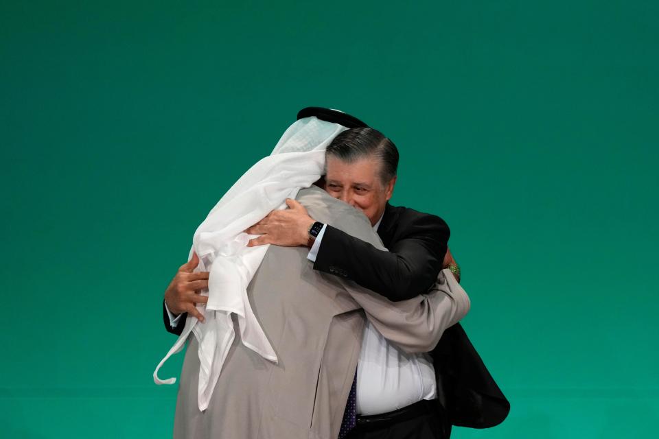 Cop28 president Sultan al-Jaber, left, and Cop28 CEO Adnan Amin embrace during a plenary session at the Cop28 (AP)