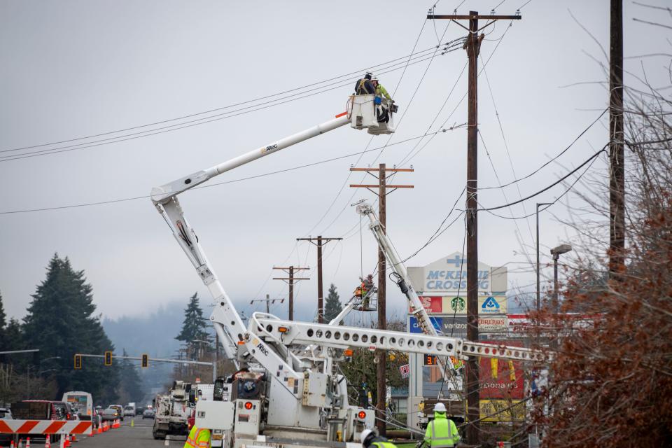 Line crews work to restore utility lines near the intersection of Main Street and Bob Straub Parkway as winter storm recovery continues Jan. 19 in Springfield.