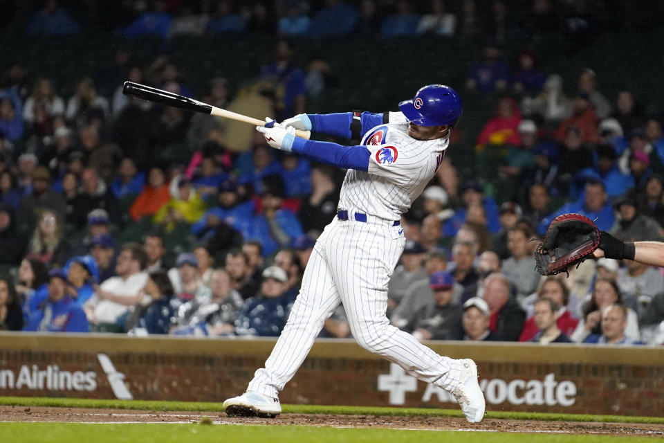 Chicago Cubs' Ian Happ swings through a three-run home run off Pittsburgh Pirates starting pitcher Luis Ortiz during the first inning of a baseball game Tuesday, June 13, 2023, in Chicago. (AP Photo/Charles Rex Arbogast)