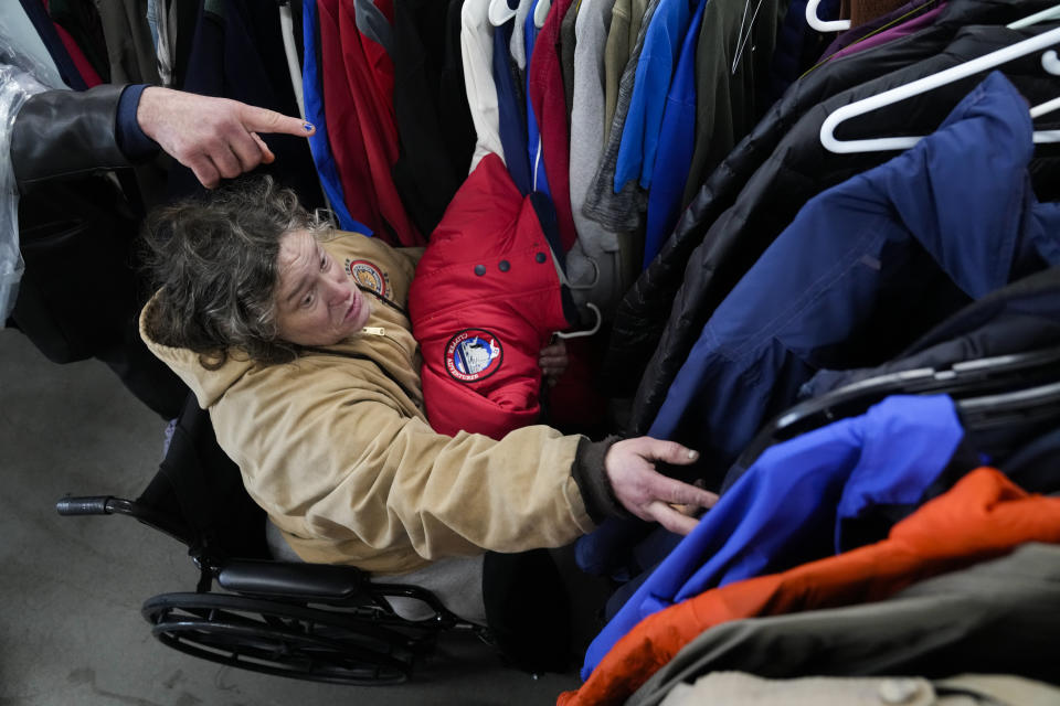 Katherine Hoffman looks through coats at a donation center on Thursday, Jan. 11, 2024, in Portland, Ore. In just one hour, during Blanchet House's free lunch service, over 100 warm clothing items were claimed from the donation racks. (AP Photo/Jenny Kane)