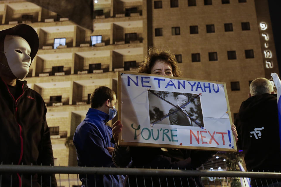 An Israeli protester holds a sign with a photo of President Donald Trump, calling for the ouster of Prime Minister Benjamin Netanyahu, shortly after results of the U.S. presidential election were announced, during a protest against Netanyahu in Jerusalem, Saturday, Nov. 7, 2020. Thousands of Israelis protested against Netanyahu, a close ally of Trump, demanding he step down because of his handling of the coronavirus crisis and the corruption charges he faces. (AP Photo/Maya Alleruzzo)
