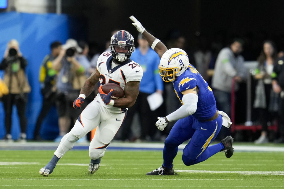 Denver Broncos running back Samaje Perine (25) carries the ball against Los Angeles Chargers linebacker Kenneth Murray Jr. (9) during the first half of an NFL football game Sunday, Dec. 10, 2023, in Inglewood, Calif. (AP Photo/Marcio Jose Sanchez)