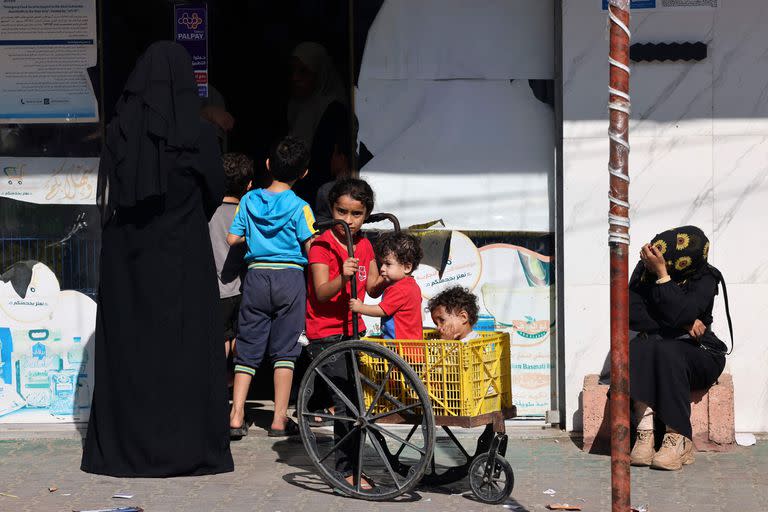 Palestinos aguardan para recibir alimentos afueras de un supermercado en Rafah, en la frontera con Egipto (MOHAMMED ABED / AFP)