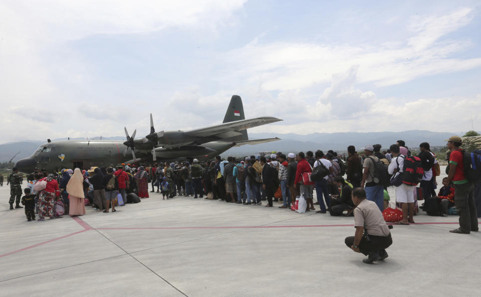 People line up to board an Air Force cargo plane at the Mutiara Sis Al-Jufri airport to evacuate the earthquake and tsunami-damaged city of Palu, Central Sulawesi Indonesia, Thursday, Oct. 4, 2018. Life is on hold for thousands living in tents and shelters in the Indonesian city hit by a powerful earthquake and tsunami, unsure when they'll be able to rebuild and spending hours each day often futilely trying to secure necessities such as fuel for generators. (AP Photo/Tatan Syuflana)