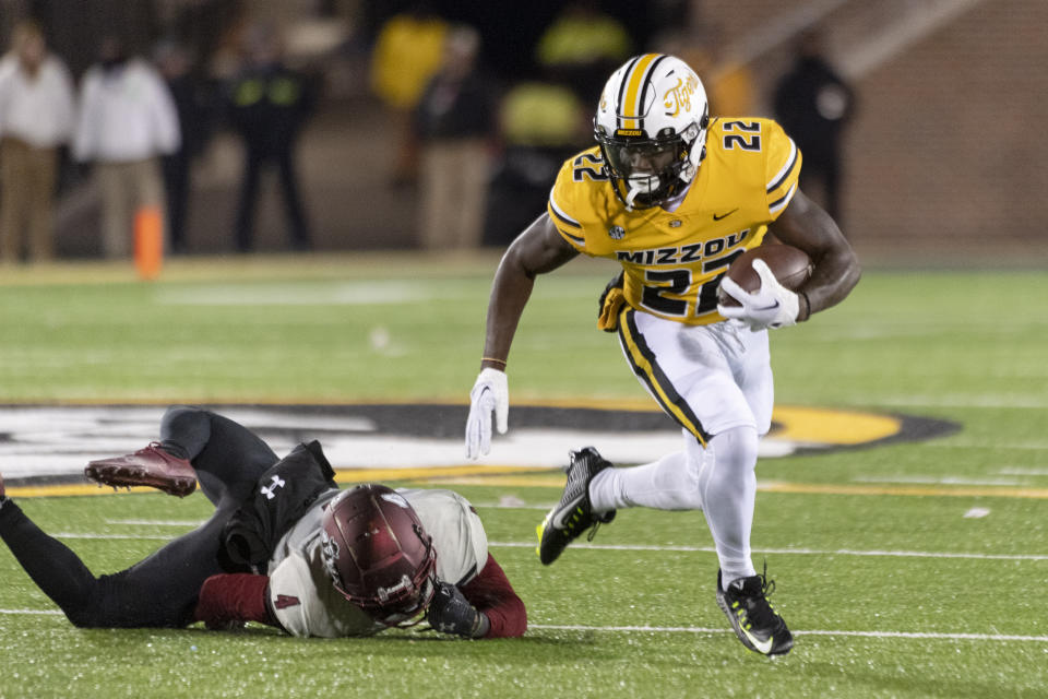 Missouri running back Tavorus Jones, right, runs pasts New Mexico State defensive back BJ Sculark during the fourth quarter of an NCAA college football game Saturday, Nov. 19, 2022, in Columbia, Mo. Missouri won 45-14. (AP Photo/L.G. Patterson)