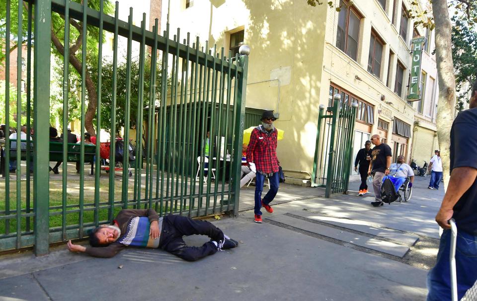 A homeless person sleeps on the street in Skid Row, downtown Los Angeles, California in October 2018. Unsanitary conditions of street encampments for the homeless population is believed to have contributed to a recent outbreak of typhus, according to Los Angeles County Department of Public Health.