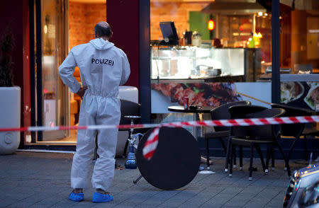 A police forensic expert works outside where a 21-year-old Syrian refugee killed a woman with a machete and injured two other people in the city of Reutlingen, Germany July 24, 2016. REUTERS/Vincent Kessler