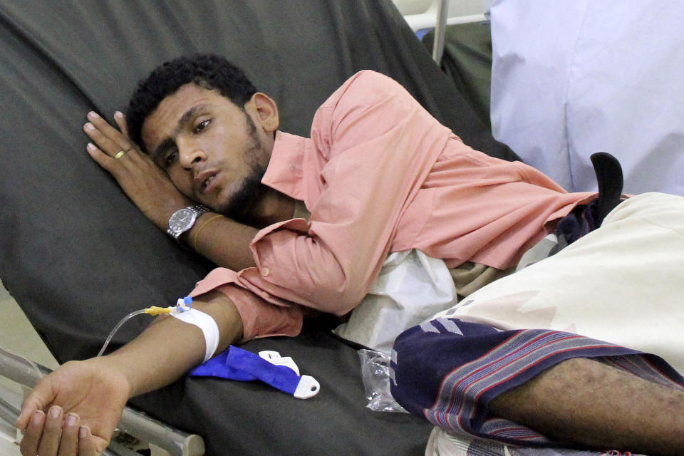 FILE - In this May 12, 2020 file photo, a Yemeni man receives treatment as he lies on a bed at a hospital in Aden, Yemen. Aid organizations are making an urgent plea for donations to shore up their operations in war-torn Yemen, saying they’ve already been forced to stop some of their work even as the coronavirus rips through the country. The calls for funds come ahead of a UN donor conference, hosted virtually by Saudi Arabia, scheduled to take place Tuesday, June 2, 2020. (AP Photo/Wail al-Qubaty, File)