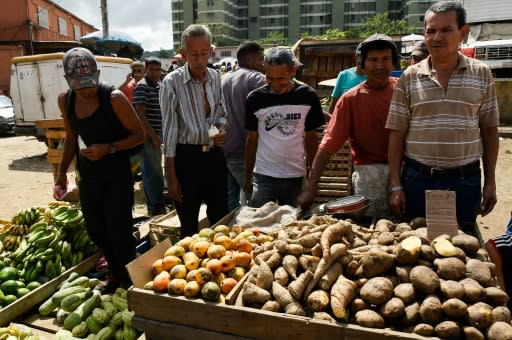 People buy groceries at the municipal market of Coche, a neighborhood in Caracas