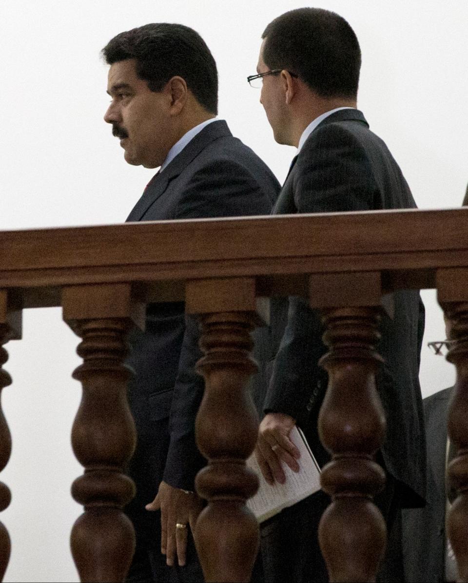 Venezuela's President Nicolas Maduro, left, speaks with Vice President Jorge Arreaza after their meeting with opposition leaders in Caracas, Venezuela, Tuesday, April 8, 2014. Opposition leaders agreed to a preliminary meeting after being assured by a mission of South American diplomats that the government is open to discussing a four-point agenda it's put forth as a starting point for talks. (AP Photo/Fernando Llano)