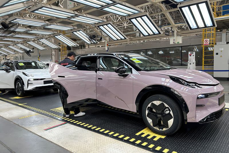 FILE PHOTO: Staff members work on an assembly line manufacturing Zeekr X trial production models, at the Geely's plant in Chengdu