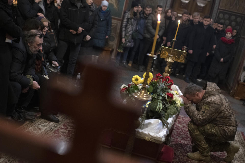 Relatives, friends, and comrades mourn next to the coffin of Ukrainian serviceman Sergii Myronov, killed fighting Russian troops in Donetsk region, during a funeral ceremony at St. Michael's Golden-Domed Monastery in Kyiv, Ukraine, Wednesday, Nov. 23, 2022. (AP Photo/Andrew Kravchenko)