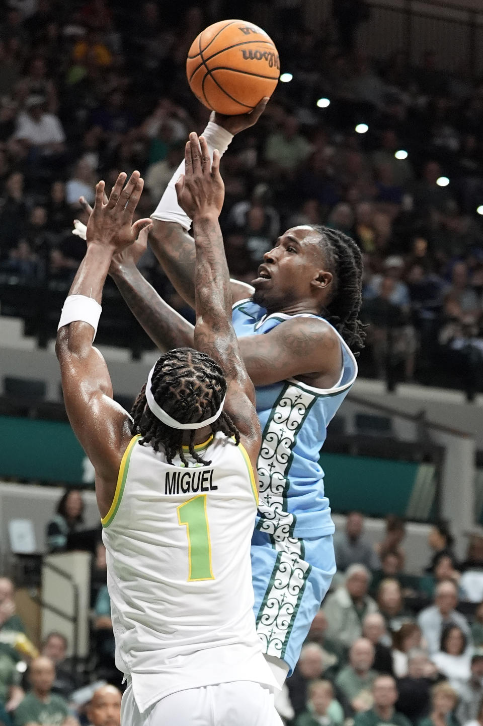 **CORRECTS TUALNE PLAYER TO Kevin Cross**Tulane forward Kevin Cross (24) shoots over South Florida guard Selton Miguel (1) during the first half of an NCAA college basketball game Tuesday, March 5, 2024, in Tampa, Fla. (AP Photo/Chris O'Meara)