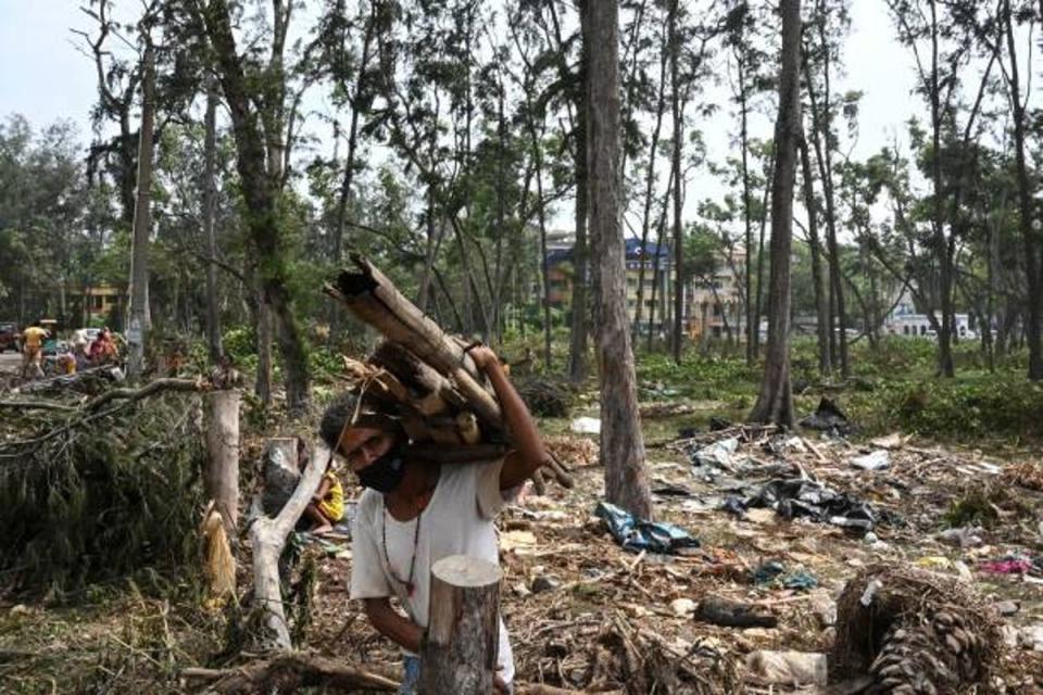 A resident collects debris from a damaged area near a beach after Cyclone Yaas hit India’s eastern coast in the Bay of Bengal in Digha, some 190 km from Kolkata on 27 May 2021 (AFP via Getty Images)