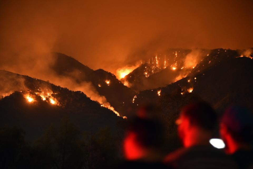 <p>People watch flames from the Holy Fire outside Glen Ivy Hot Springs in Corona, California, southeast of Los Angeles on Aug. 10, 2018. (Photo: Robyn Beck/AFP/Getty Images) </p>