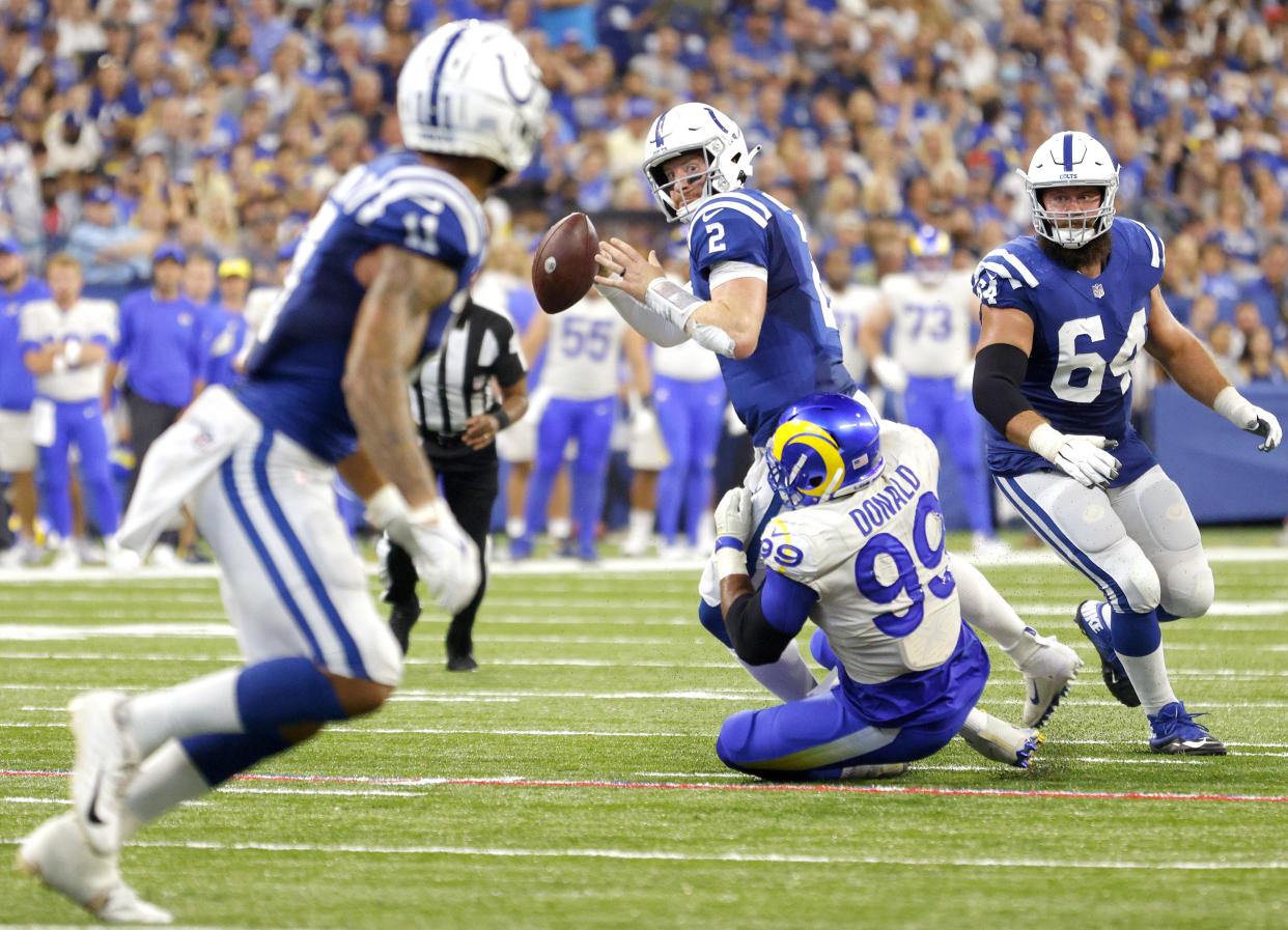 INDIANAPOLIS, INDIANA - SEPTEMBER 19: Quarterback Carson Wentz #2 of the Indianapolis Colts looks to throw the ball while being tackled by defensive end Aaron Donald #99 of the Los Angeles Rams in the game at Lucas Oil Stadium on September 19, 2021 in Indianapolis, Indiana. (Photo by Michael Hickey/Getty Images)