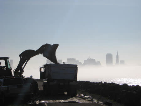 A front end loader loads a truck with debris at a worksite within the housing neighbourhood on Treasure Island, near San Francisco, California, U.S., in this January 2008 handout photo. Handout via REUTERS