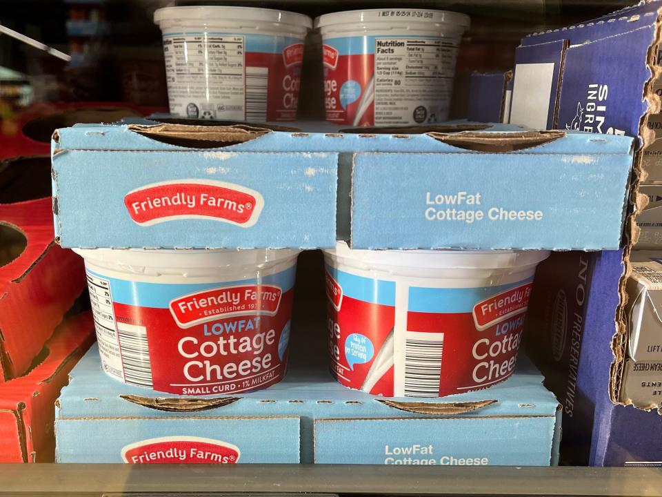 Containers of Friendly Farms low-fat cottage cheese in a refrigerator at Aldi. The price tag reads $2.50.
