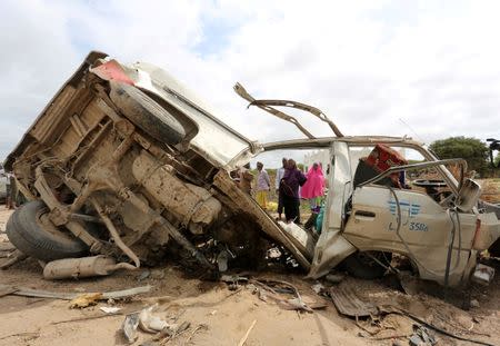 Residents gather to look at the wreckage of a minibus destroyed in roadside bomb in Lafoole village near Somalia's capital Mogadishu, June 30, 2016. REUTERS/Feisal Omar