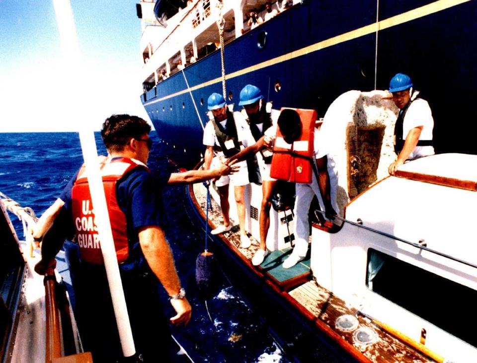 Una embarcación de la Guardia Costera se acerca a un balsero cubano recogido en los Cayos de la Florida por el yate Britannia de la reina Isabel, atrás.