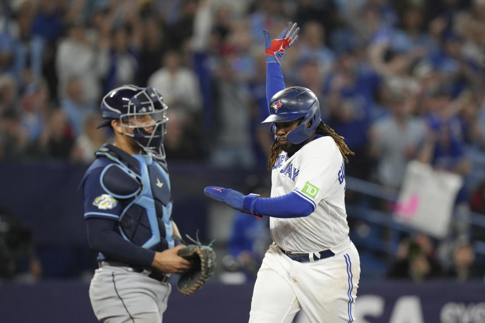Toronto Blue Jays' Vladimir Guerrero Jr. celebrates in front of Tampa Bay Rays catcher Rene Pinto while scoring during the sixth inning of a baseball game Friday, Sept. 29, 2023, in Toronto. (Chris Young/The Canadian Press via AP)