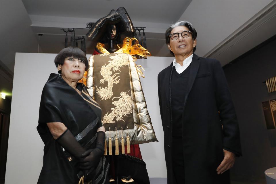 Japanese fashion designer Junko Koshino (L) and Japanese-French fashion designer Kenzo Takada (R) pose next to a Kimono created by Koshino during the inauguration of the exhibition "Kimono - Au bonheur des dames" at the Guimet museum in Paris, on February 21, 2017. The exhibition will run from February 22 to May 22, 2017. / AFP / PATRICK KOVARIK / RESTRICTED TO EDITORIAL USE - MANDATORY MENTION OF THE ARTIST UPON PUBLICATION - TO ILLUSTRATE THE EVENT AS SPECIFIED IN THE CAPTION (Photo credit should read PATRICK KOVARIK/AFP via Getty Images)