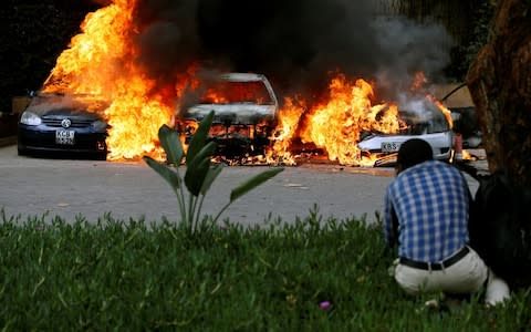 Cars are seen on fire at the scene of explosions and gunshots in Nairobi - Credit: REUTERS/Thomas Mukoya