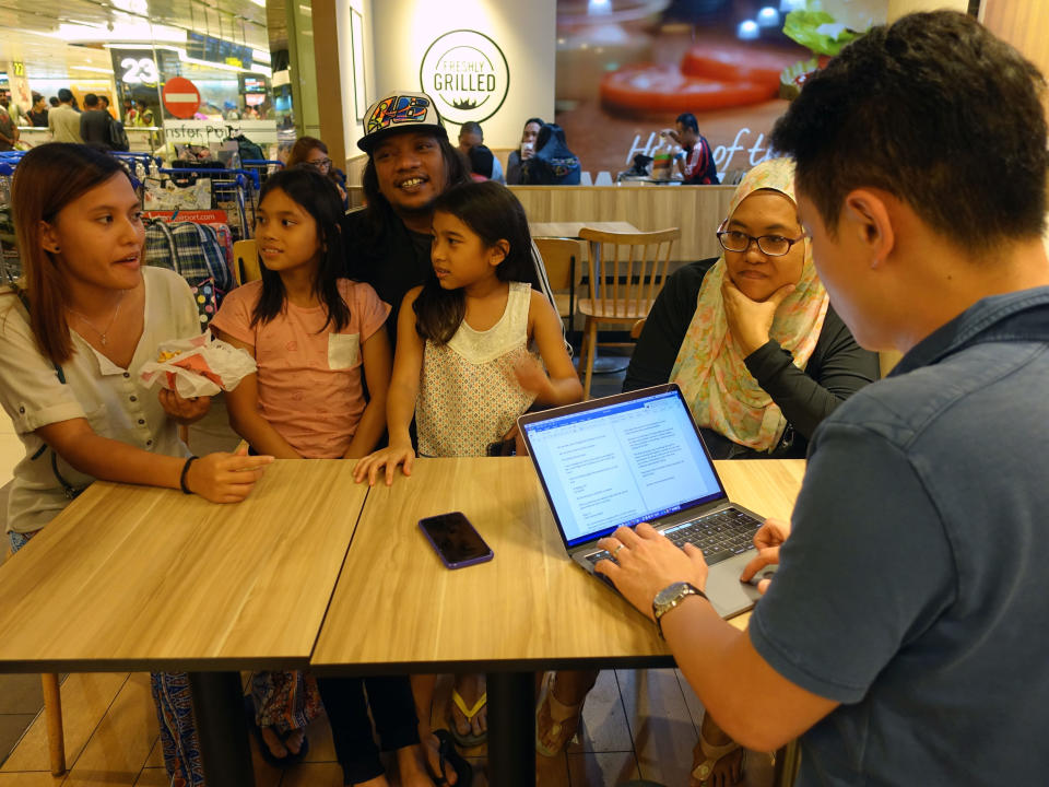 Nisa Anuar, her cousin Shah Ali (in cap) and their family friend Sri Rahayu (right) speaking with Yahoo News Singapore senior correspondent Nicholas Yong. (PHOTO: Nurul Azliah / Yahoo News Singapore)