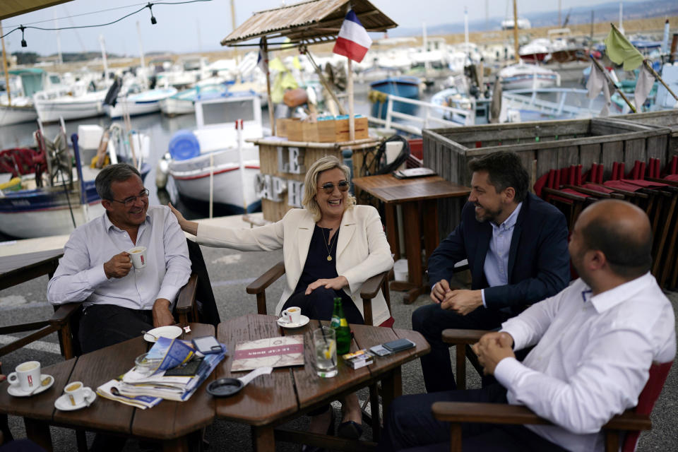 FILE - In this June 17, 2021, file photo, far-right leader Marine le Pen, center, and local candidate Thierry Mariani, left, enjoy a drink at a cafe terrace in Six-Fours-les-Plages, southern France. Le Pen’s once-ascendant far-right party is struggling ahead of runoff elections for France's regional leadership. Its best chance of victory is Mariani, a European lawmaker who meets regularly with Syrian dictator Bashar al-Assad and celebrated Russia’s annexation of Crimea. (AP Photo/Daniel Cole, File)