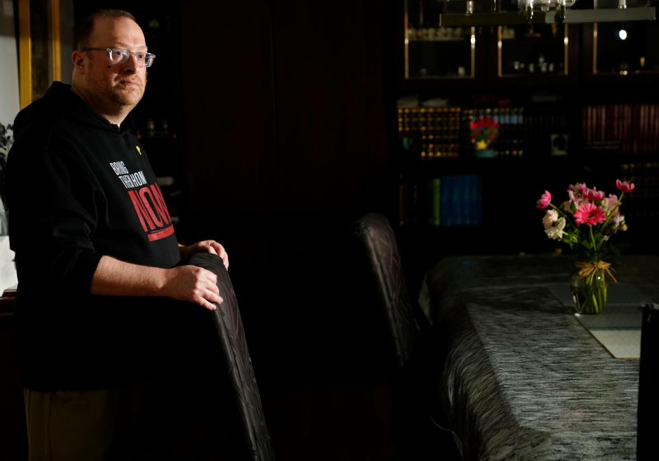 Daniel Rothner poses by an empty chair in his Teaneck home, Wednesday, April 17, 2024. Rothner and his family will keep an empty chair at their table during their Passover seder in honor of those who remain kidnapped since October 7.