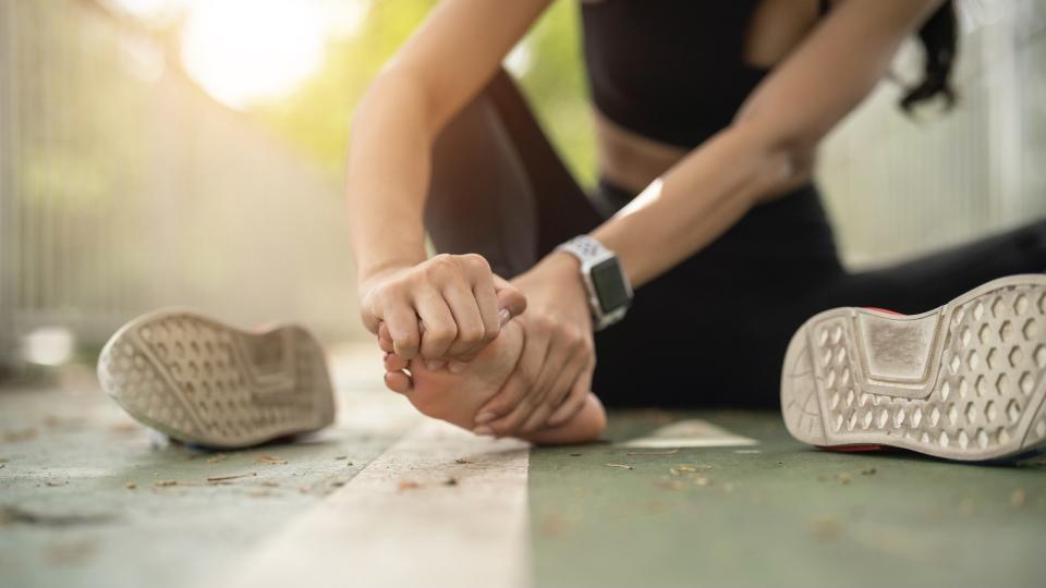 Woman holding foot in pain