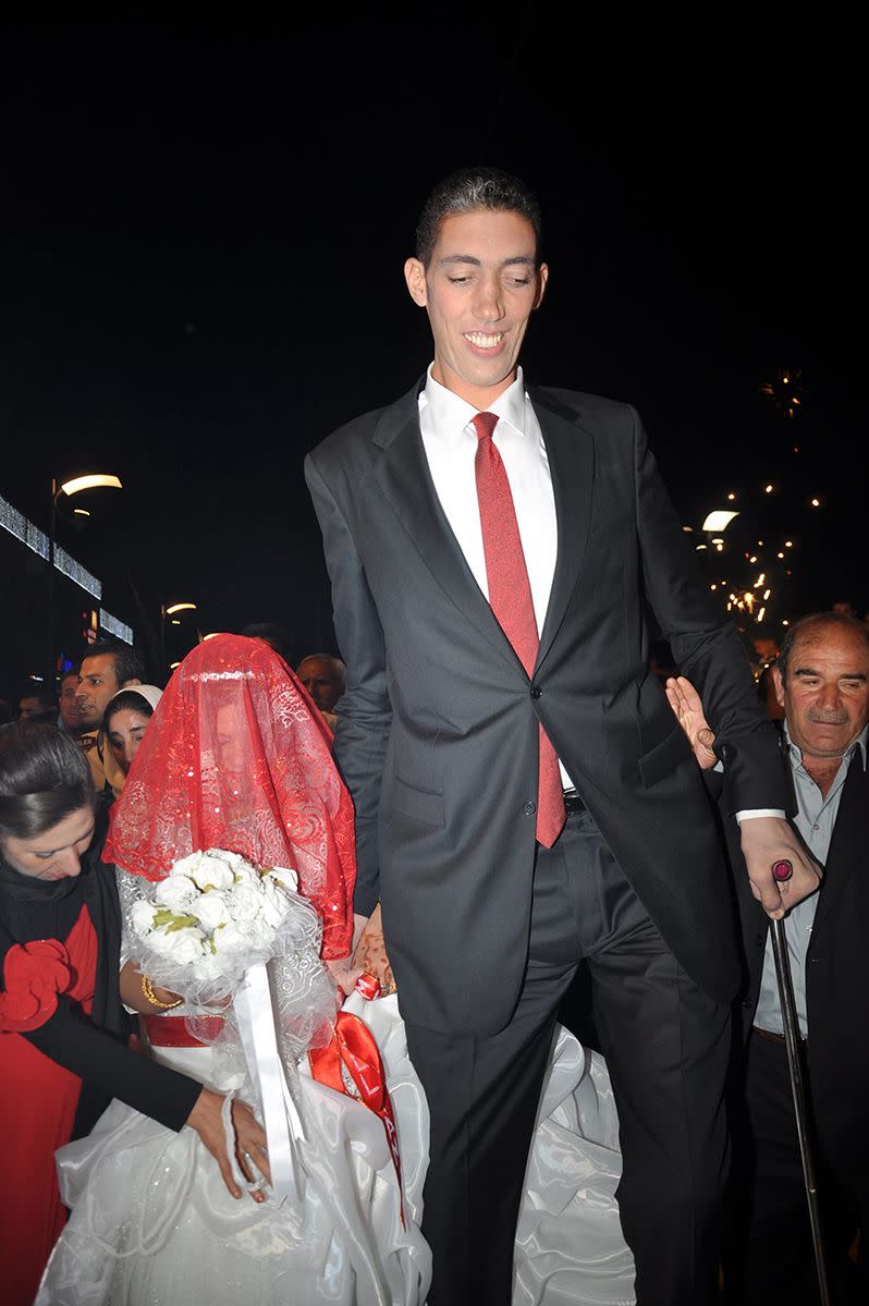 The world's tallest man, Sultan Kosen, arrives with his new wife to their wedding ceremony. Photo: AAP.