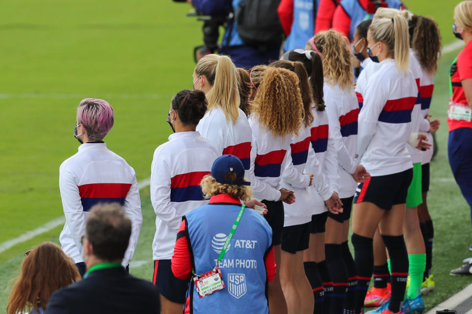 United States backup players, including Megan Rapinoe (L), stand for the United States National anthem against Brazil prior to  the SheBelieves Cup at Exploria Stadium on February 21, 2021 in Orlando, Florida. / Credit: Alex Menendez / Getty Images