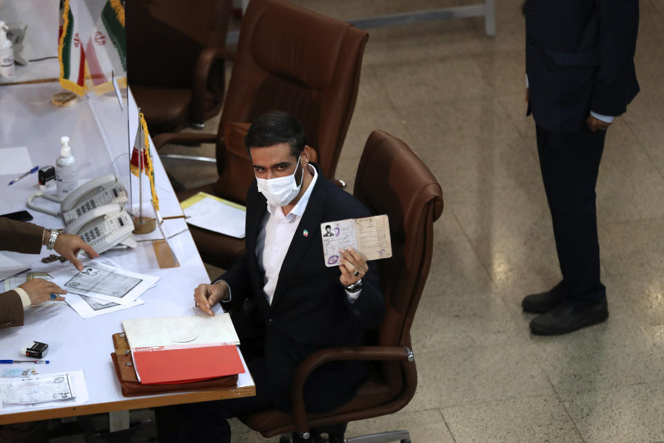 Revolutionary Guard Gen. Saeed Mohammad, who once headed the paramilitary force's Khatam al-Anbiya Construction Headquarters, shows his identification document while registering his name as a candidate for the June 18 presidential elections at the elections headquarters of the Interior Ministry in Tehran, Iran, Tuesday, May 11, 2021. Iran opened registration Tuesday for potential candidates in the country's June presidential election, kicking off the race as uncertainty looms over Tehran's tattered nuclear deal with world powers and tensions remain high with the West. (AP Photo/Vahid Salemi)