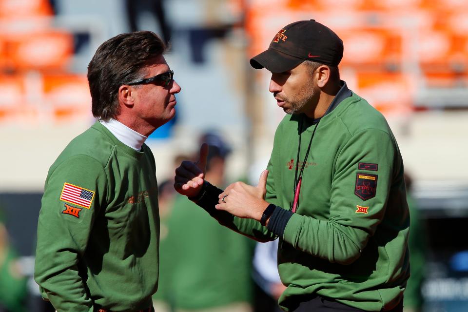 Head coach Mike Gundy of the Oklahoma State Cowboys talks with head coach Matt Campbell of the Iowa State Cyclones before their game at Boone Pickens Stadium on November 12, 2022 in Stillwater, Oklahoma.