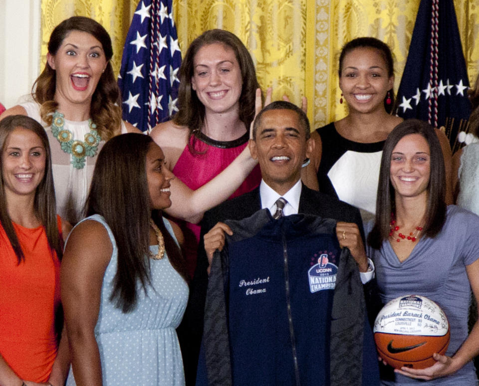 FILE - In this July 31, 2013 file photo, University of Connecticut Huskies teammates Stefanie Dolson, top left, and Kiah Stokes, top right, give the 'bunny ears' to President Barack Obama as he poses for photo with the team to honor their 2013 NCAA Women’s Basketball Championship win, during a ceremony in the East Room of the White House in Washington. Also seen top center Breanna Stewart, and from bottom left, Caroline Doty, Kaleena Mosqueda-Lewis and Kelly Faris. On Saturday, March 1, 2014, Dolson and fellow senior Bria Hartley will have their names added to the “Huskies of Honor” wall at Gampel Pavilion on the UConn campus in Storrs, Conn. (AP Photo/Carolyn Kaster, File)