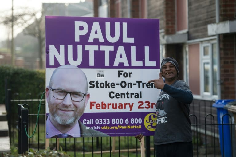 A Fijian resident of Stoke-on-Trent stands next to a large campaign poster supporting UKIP outside his home in Stoke-on-Trent, central England